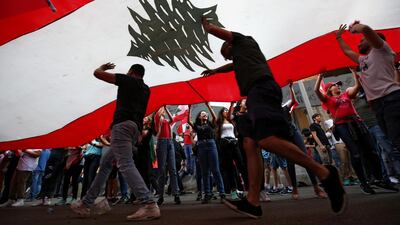Demonstrators carry national flags during anti-government protests in downtown Beirut. REUTERS