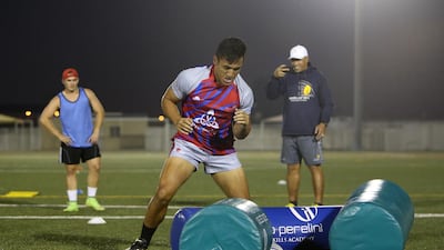 Noah Perelini, centre, during a rugby training session with his father Apollo Perelini, right, at Repton school in Dubai. Pawan Singh / The National