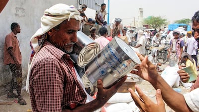 A Yemeni civilian receives food aid for displaced people who fled battles in the Red Sea province of Hodeida and are now living in camps in the northern district of Abs. AFP