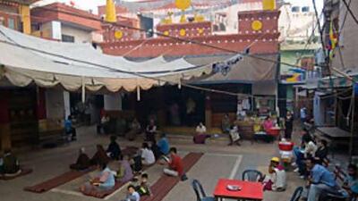 Tibetans congregate outside their colony's Buddhist temple in Delhi for morning prayers.