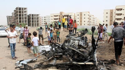 People gather at the site of a car bomb attack that targeted the convoy of Aidarous Al Zubaidi, the governor of Aden. The governor and Aden’s police chief, Maj Gen Shalal Shaei, escaped unhurt. Reuters