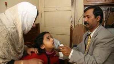 Dr Timir Garal, right, uses a nebuliser to treat Sarah Akhtar at a clinic in Kolkata.