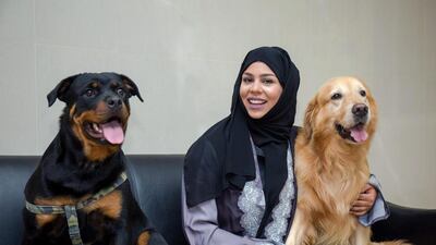 Sara Al Zaki helps rescue and rehome banned breeds of animals that have been used in dog fighting. She is seen with Dusty the Rottweiler, left, and Jess the Golden Retriever. Victor Besa for The National