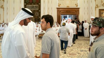 Sheikh Mohamed shakes hands with a member of Zayed Higher Organisation for People of Determination.