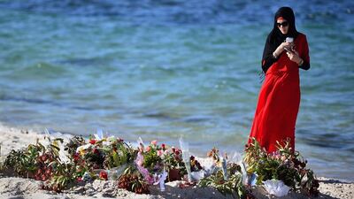 A woman looks at flowers laid on Marhaba beach in Sousse, where 38 people were killed in last Fridays terror attack in Sousse. Jeff J Mitchell / Getty Images