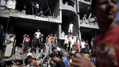 Palestinian gather around the rubble of a building destroyed following an Israeli military strike in Rafah in the south of the Gaza Strip. The armed wing of Hamas announced that three of its senior commanders were killed in a pre-dawn Israeli air strike in southern Gaza that medics said killed seven people. Thomas Coex / AFP