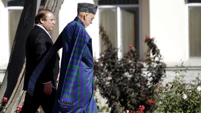 Former Afghan President Hamid Karzai walks with Pakistan's Prime Minister Nawaz Sharif during their 2013 meeting in Kabul S Sabawoon / EPA
