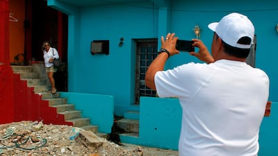Jose Vazquez, right, takes a photo of his wife Ana Soto in the neighbourhood of La Perla. Ricardo Arduengo / AFP