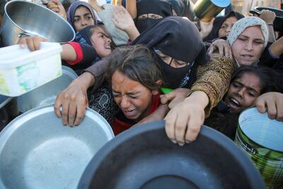 Palestinians gather to receive food cooked by a charity kitchen, amid a rising hunger crisis in the southern Gaza Strip on Tuesday. Reuters