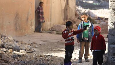 Iraqi children play in a debris-strewn alleyway in Mosul's Old City on January 8, 2018, as a few people venture to return to the area. Ahmad Al Rubaye / AFP