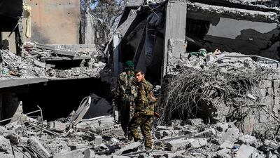 Members of the Syrian Democratic Forces (SDF), backed by US special forces, make their way through the rubble on the western frontline of Raqqa on October 8, 2017. Bulent Kilic / AFP