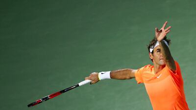 Roger Federer serves to Mikhail Youzhny during a first round win in the ATP Dubai Duty Free Tennis Championships on Monday. Marwan Naamani / AFP