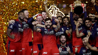 Royal Challengers Bengaluru players with the IPL trophy after defeating Gujarat Titans in the final in Ahmedabad. Reuters