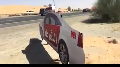 Screengrab taken from a Facebook video showing full size cardboard cutouts of a police cars in UAQ.