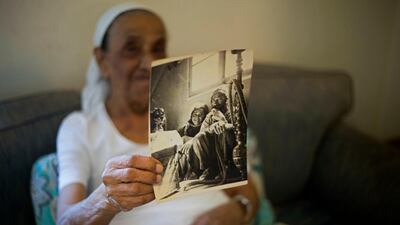 Yemen born Jewish Israeli Yona Josef holds a photograph dated back to the 1940's of her and her father back in Yemen in her home in Raanana, Israel. Ms Josef said she was asked to take her 4-year-old sister Saada to a health clinic and leave her there. When she returned several hours later, she was told her sister was dead and the family was given no further details or a body to bury. AP