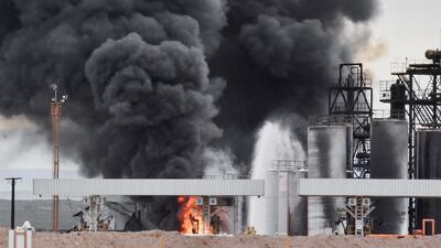 Firefighters work to keep the flames from spreading to adjoining tanks. Reuters