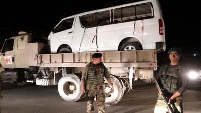 Afghan security officials remove a damaged vehicle after a suicide bomb attack targeted the Marshal Fahim military academy in Kabul on Saturday. Hedayatullah Amid / EPA