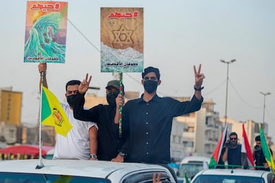 Iraqi protesters hold posters during a rally in Baghdad in support of Palestinians, bearing the name 'Operation Al Aqsa Flood'. AFP