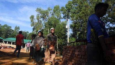 Bangladeshi labourers carry bricks in the construction site of the "Transit Camp". AFP