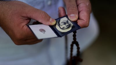 A visitor prayers near Mother Teresa's tomb, while holding a picture of the late missionary, during a Mass marking the 28th anniversary of her death, at the Missionaries of Charity in Kolkata, India . EPA