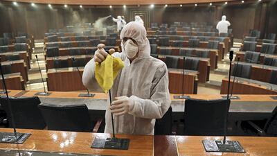 Sanitary workers disinfect the desks and chairs of the Lebanese Parliament in central Beirut on March 10, 2020 amid the spread of coronavirus in the country. AFP