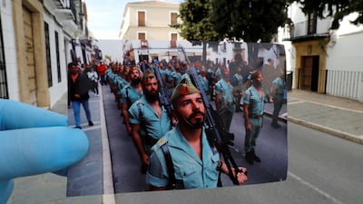 A Reuters photographer holds a picture of Spanish legionnaires marching before a procession taken in April, 2019, in front of the street of the procession, on Palm Sunday, the first day of Holy Week, amid the coronavirus disease outbreak, in Ronda, southern Spain. Reuters