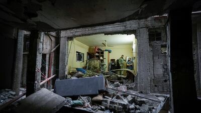 Palestinians in the Balata refugee camp near the West Bank town of Nablus inspect a damaged building following an Israeli army raid. AP