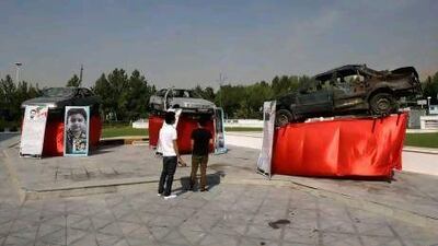 Damaged cars that three Iranian scientists, Masoud Ali Mohammadi, right, Majid Shahriari, centre, and Mostafa Ahmadi Roshan were riding in when they were killed in bombings over the past three years are displayed outside a conference hall hosting the meeting of the Non-Aligned Movement in Tehran.