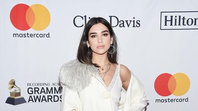 Dua Lipa, who is performing in Abu Dhabi this February, wrapped up in a jacket and boots in a monochrome, all-white outfit. Evan Agostini / AP