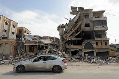 Displaced Lebanese pass a destroyed building as they return to Nabatieh. AFP