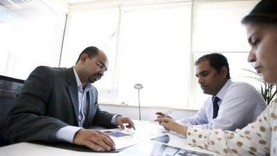 Zameer Abdul Wahab, left, Rakesh Pillai, centre, and Sonal Jakkal of Green Curve Interiors discuss site plans for a client. Sarah Dea / The National