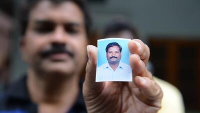 A relative holds up a photograph of Indian national, Balaram, who is thought to have been abducted in Libya, at his residence in Hyderabad on July 31. AFP Photo