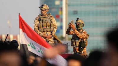 Iraqi security forces monitor a protest outside the Basra Governorate's building in the southern city of Basra. AFP