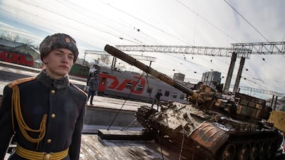 A soldier stands next to a Russia made tank T-55 standing aboard a train. AP Photo