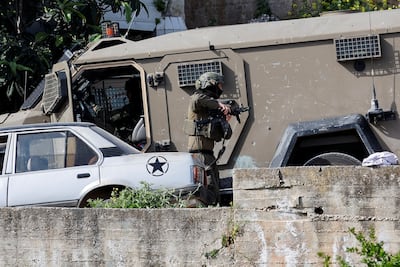 An Israeli soldier brandishes a weapon during a raid in the West Bank city of Tubas on Saturday. Reuters