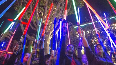 Fans of actress Carrie Fisher honoured her death by pointing their lit “Star Wars” light sabers to the sky at 7pm at Downtown Disney, in Anaheim. Mark Eades / The Orange County Register via AP