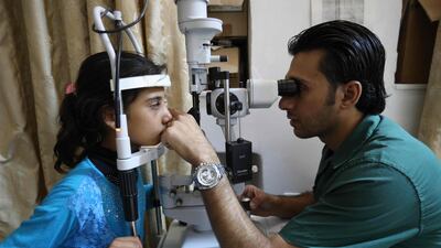 A doctor tests the eyesight of a young girl in Idlib province, Syria.