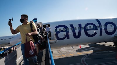 A passenger wearing a protective mask disembarking from the first Avelo Airlines flight. Bloomberg