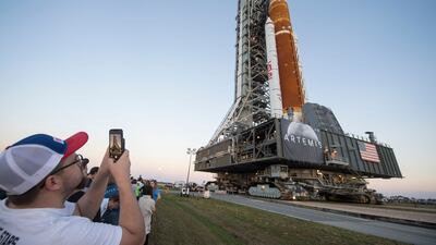 Invited guests and Nasa employees take photos as Nasa's Space Launch System rocket is rolled out of the Vehicle Assembly Building for the first time. AFP