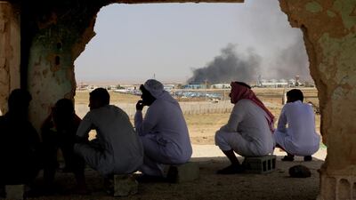 Jordanian residents of Jabir village watch aid deliveries to Syrians fleeing government offensive in the south as smoke from unknown fire rises, Tuesday, July 3, 2018. AP