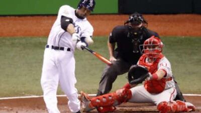 The Tampa Bay Rays batter Carl Crawford, left, hits a solo home run in the fourth inning off the Philadelphia Phillies starting pitcher Cole Hamels in Game 1.