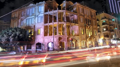 This Thursday, Oct. 26, 2017 photo, made with a long exposure, shows cars passing in front of Beit Beirut, the nearly 100 year-old house that served as a sniper position during Lebanon's civil war and now is hosting an exhibition by Zena El Khalil, in Beirut, Lebanon. El Khalil has tapped into wounds more than forty years old in war-scarred Lebanon. (AP Photo/Bilal Hussein)