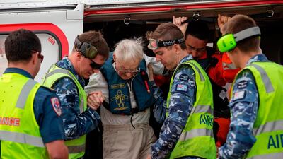 RAAF airmen and civilian search and rescue helicopter crew help an evacuated civilian at RAAF Base East Sale in Sale, during bushfire relief efforts. AFP