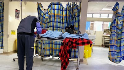 An unidentified hospital worker attends to a patient outside the consultation cubicle at the emergency section of the Kenyatta National Hospital during a doctors' strike, amid the spread of the coronavirus, in Nairobi, Kenya December 21, 2020. Reuters
