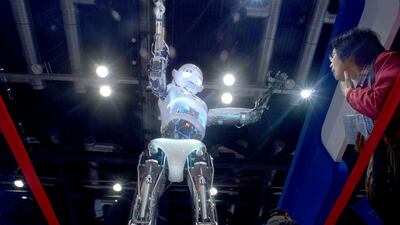 A visitor watches a robot demonstration during the World Robot Conference. Wang Zhao / AFP