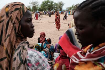 Women wait to receive food cards after registering as new arrivals at a camp for internally displaced persons in Agari, North Kordofan. AFP