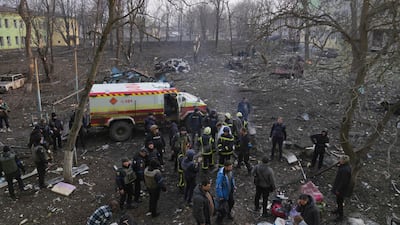 Ukrainian servicemen and firefighters stand outside the remains of a maternity hospital damaged in a shelling attack in Mariupol on March 9. AP