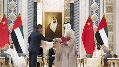 Ahmed Ali Al Sayegh, Chairman of Abu Dhabi Global Market, right, exchanges an MOU with a member of the Chinese delegation, at the Presidential Palace. Crown Prince Court - Abu Dhabi