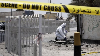 A Bahraini forensic police officer inspects the site of a bomb blast in the village of Sitra, south of Manama. Mohammed Al Shaikh/AFP
