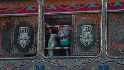 A man wearing a facemask as a preventive measure against the Covid-19 coronavirus, travels on a passenger bus in Karachi. AFP